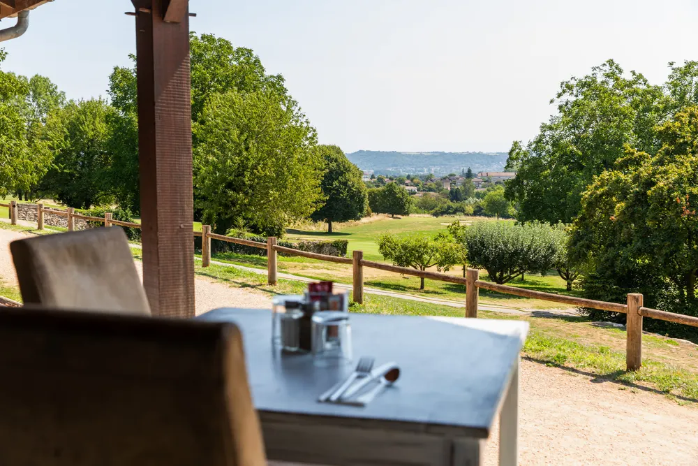 Table dressée en terrasse, face au parcours de golf