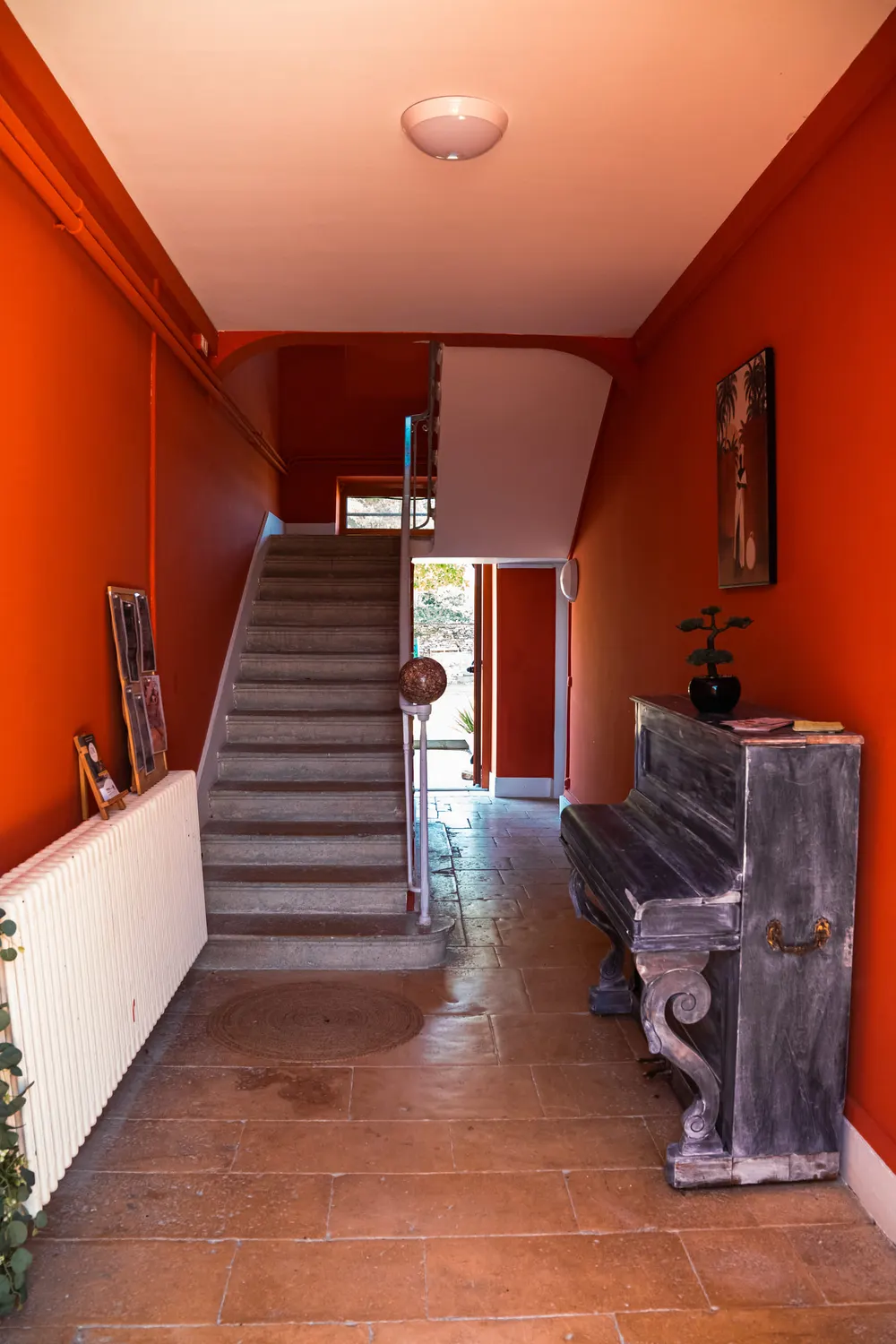 Le couloir d’entrée rouge et l’escalier de la maison