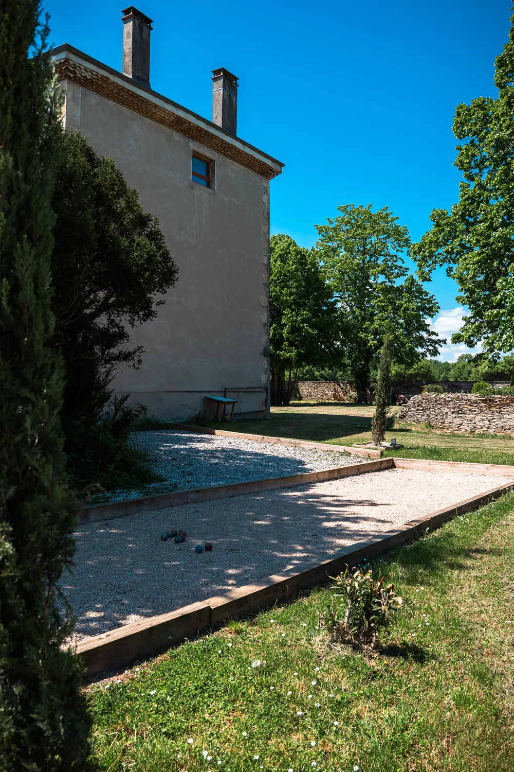 Le terrain de pétanque, le long de la maison, dans les jardins