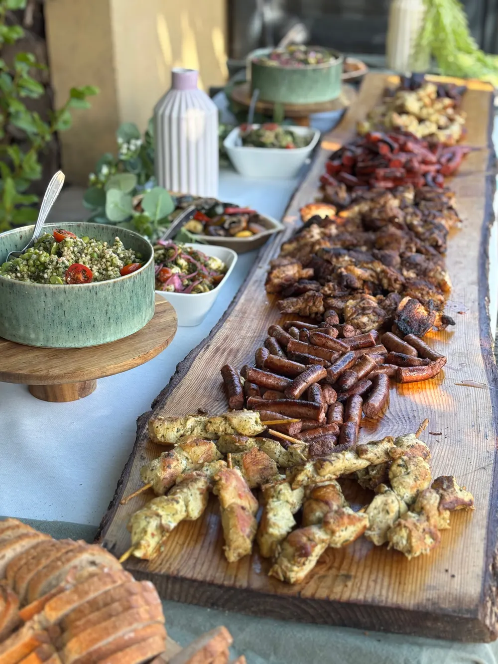 Longue table de buffet garnie de planches, de grillades et de salades